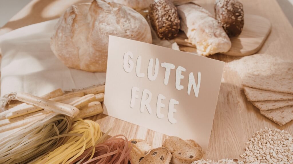 Variedade de grãos integrais, cereais e sementes em tigelas de madeira organizados ao redor de um monte de farinha integral.