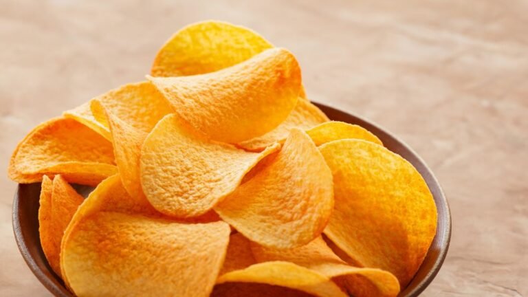 Tigela de cerâmica cheia de batatas chips crocantes.